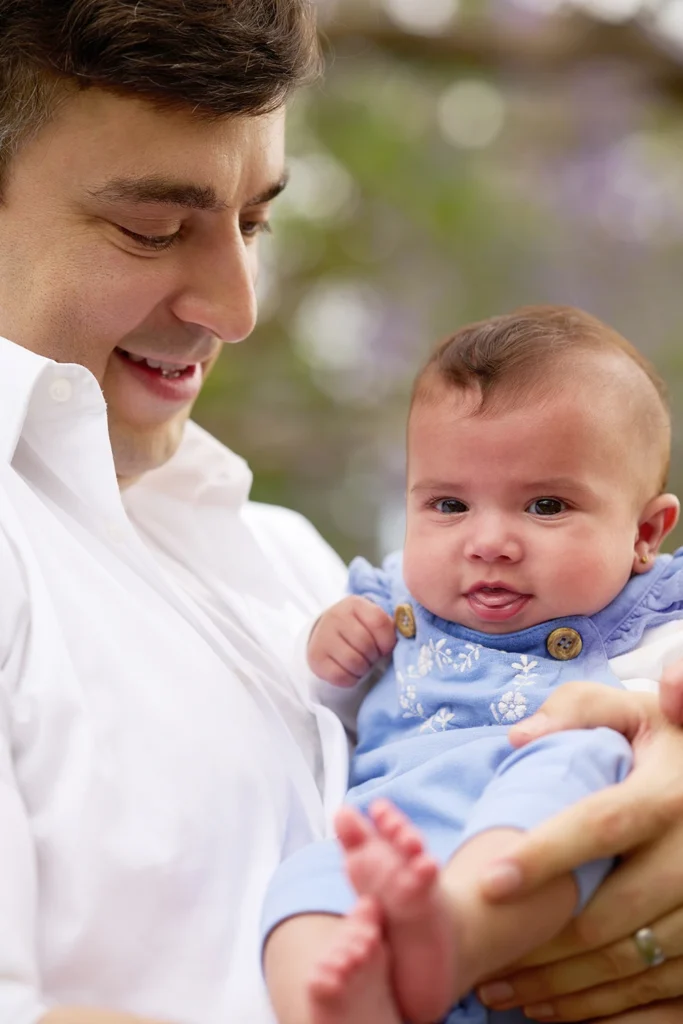 dad holding baby girl close smiling down