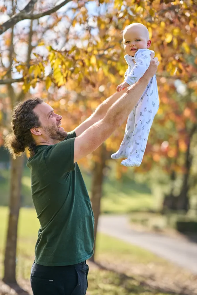dad lifting baby up at Fagan Park