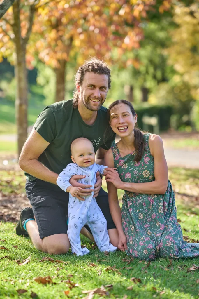 family of three sitting on grass at Fagan Park during mother's mini session