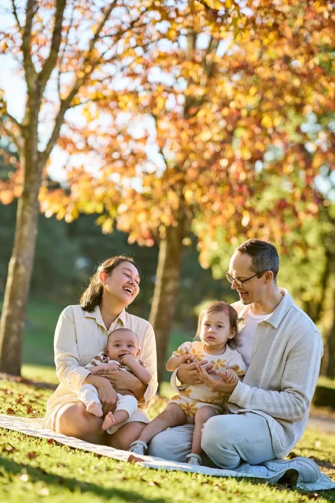 Parents with toddler and baby sitting on grass