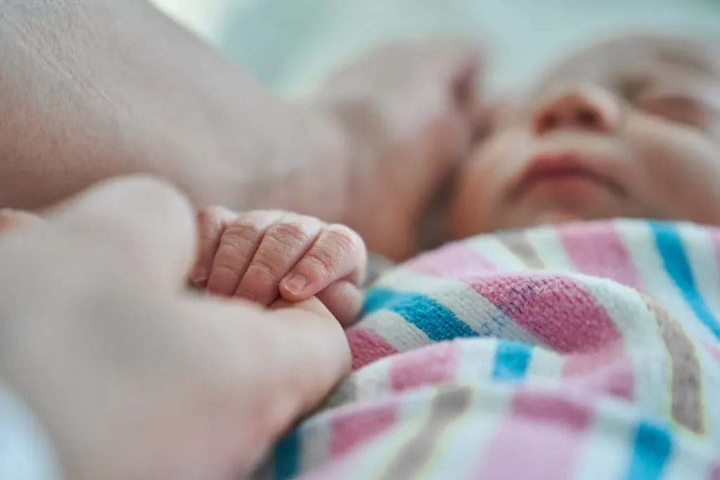 Close up of newborn hand wrapped in blanket