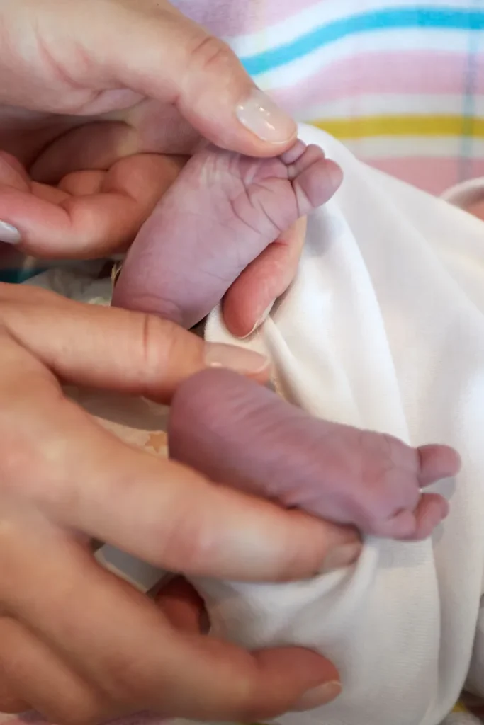Close up of tiny newborn feet and hands