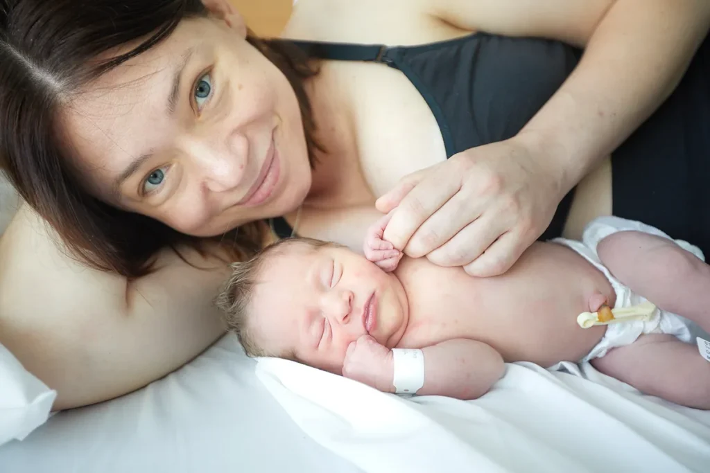 Mother holding newborn close with eyes closed