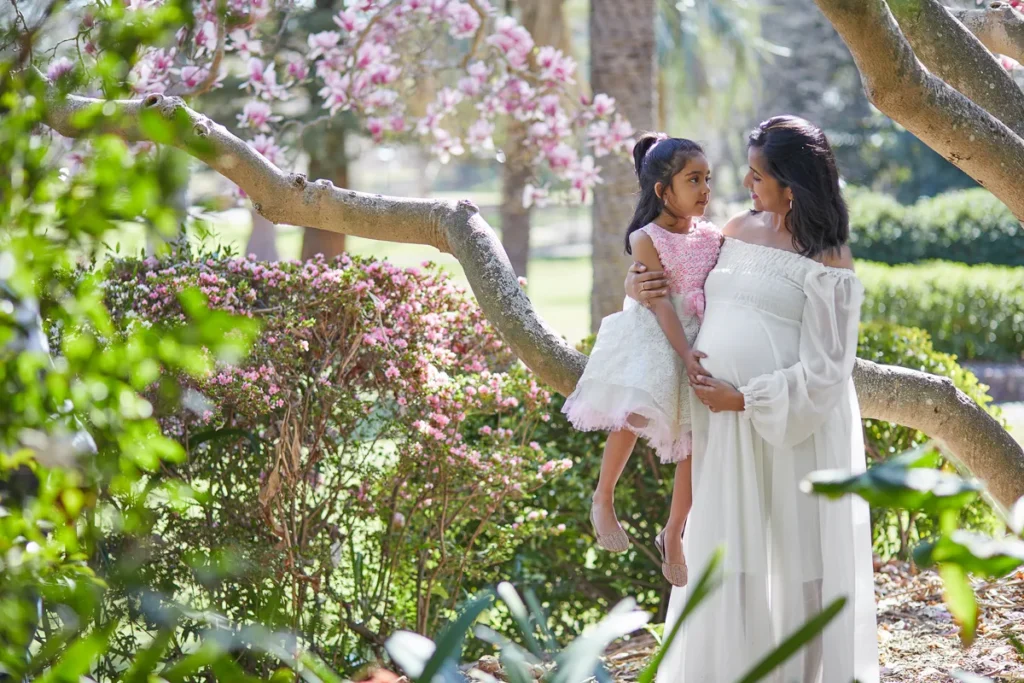 dad holding daughter under magnolia tree at Wahroonga Park