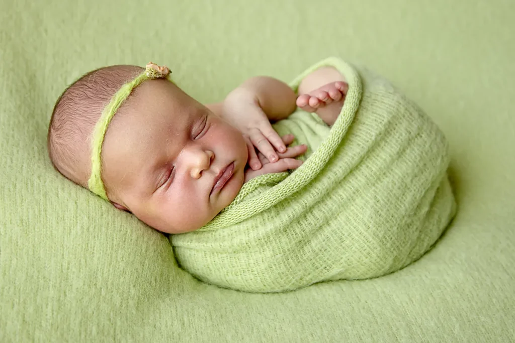 sleeping newborn wrapped in green at Hornsby studio
