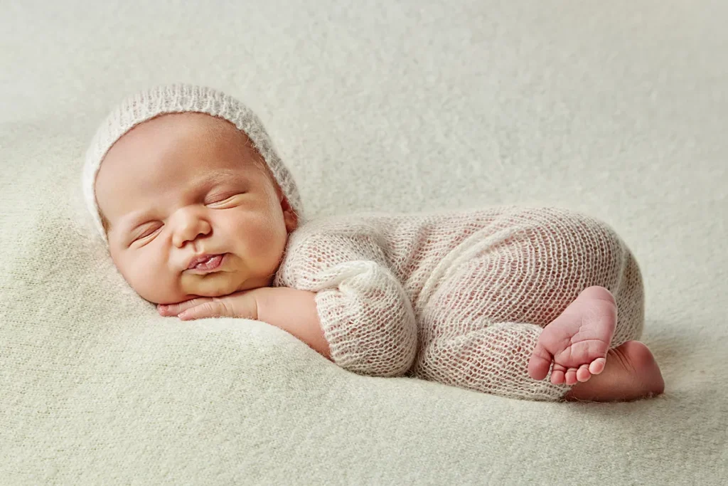newborn sleeping on tummy on white soft wrap