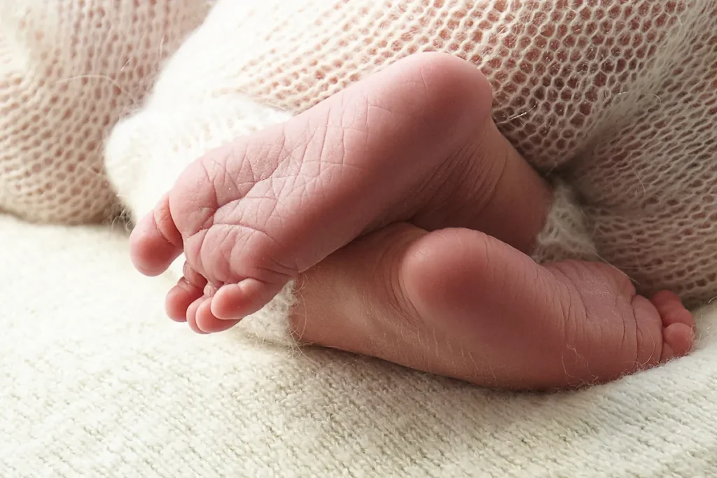 tiny baby feet resting on knit blanket