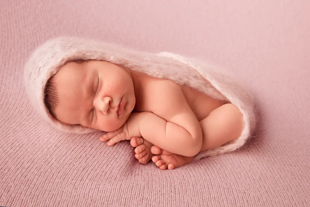 baby girl in floral headband on pink wrap