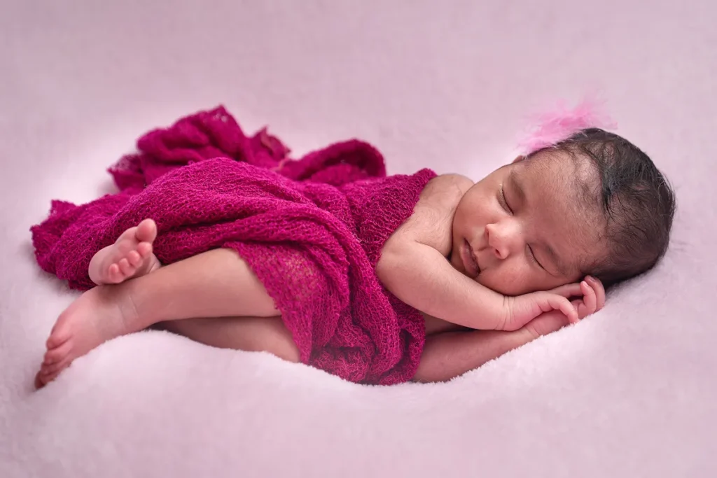 newborn wrapped in hot pink on pink backdrop in turramurra