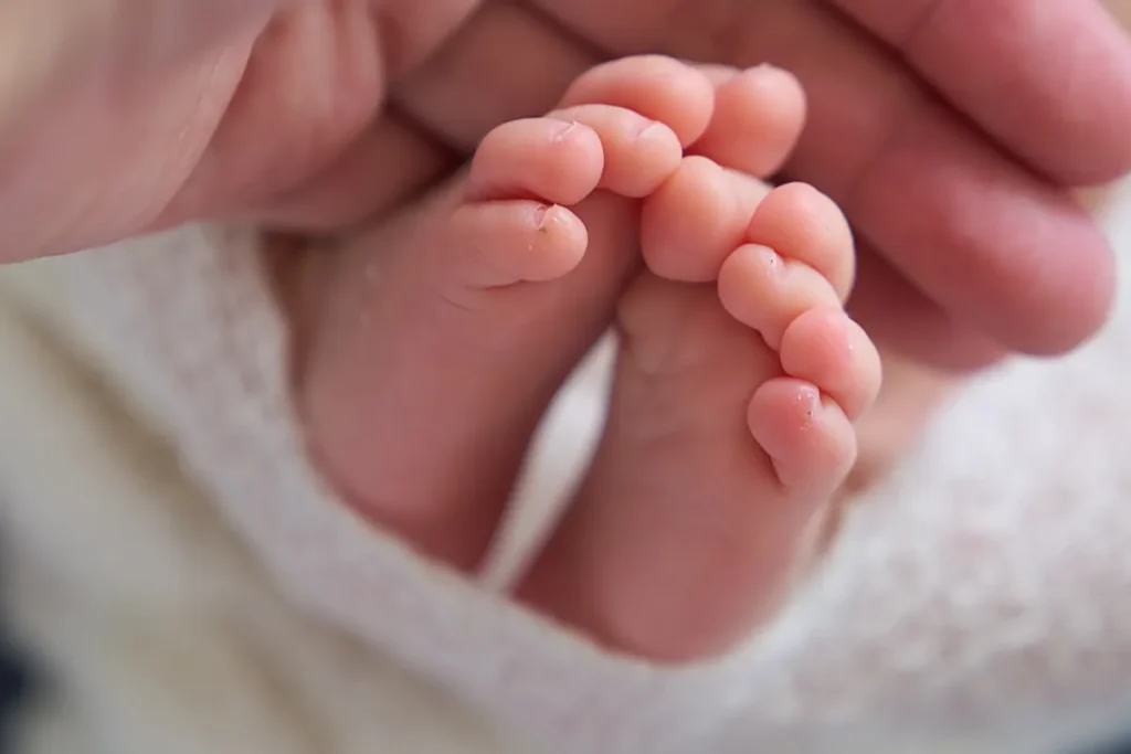 close up of tiny newborn feet on blanket