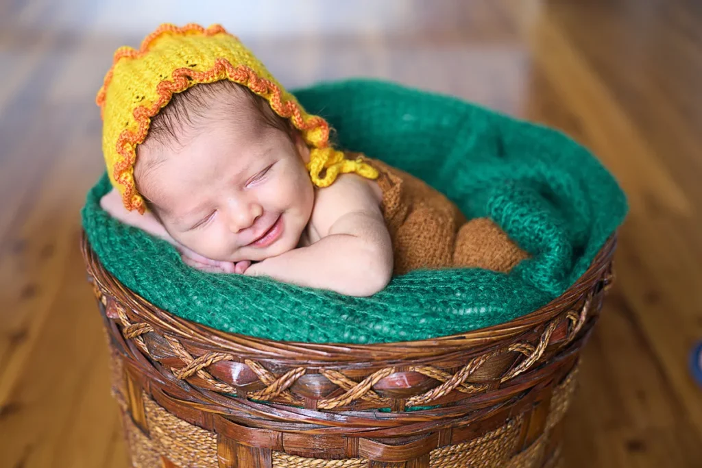 newborn in yellow hat sleeping in ethnic bowl