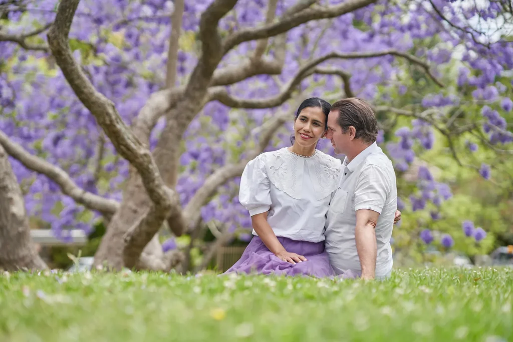 Couple sitting under jacaranda at Hornsby