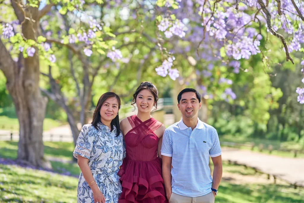 Family of three standing together at Parramatta Park