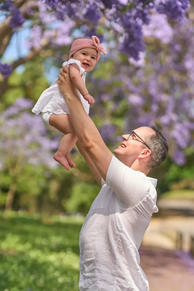 A father lifts his baby into the air