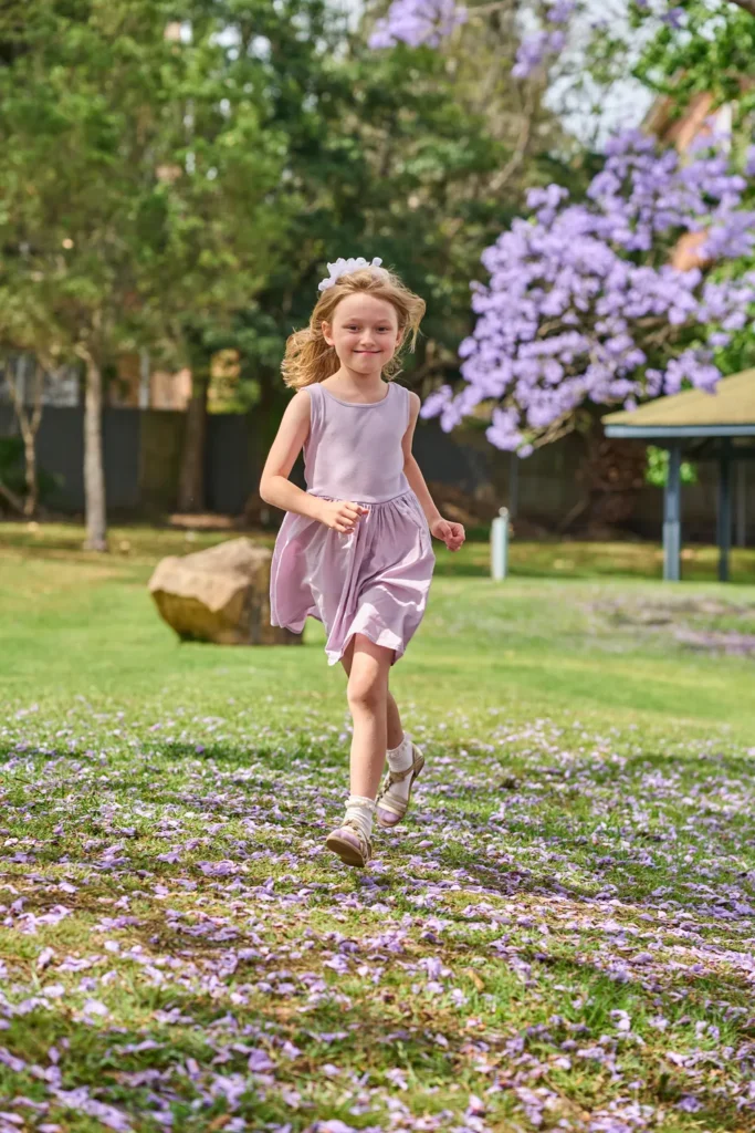 A girl runs across grass