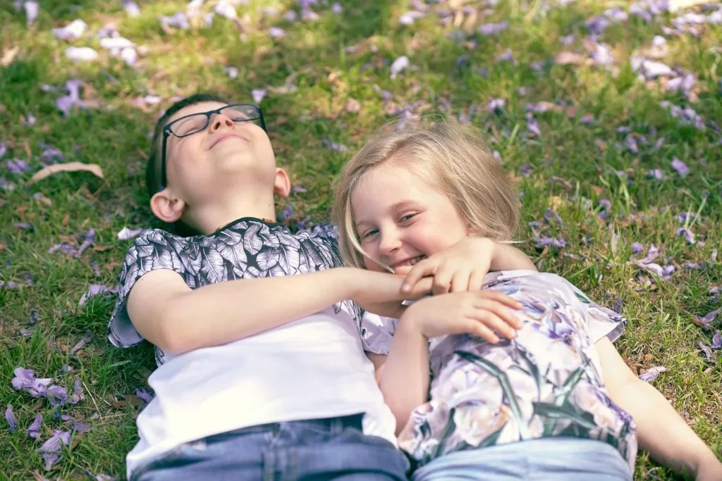 Two children lying on grass laughing