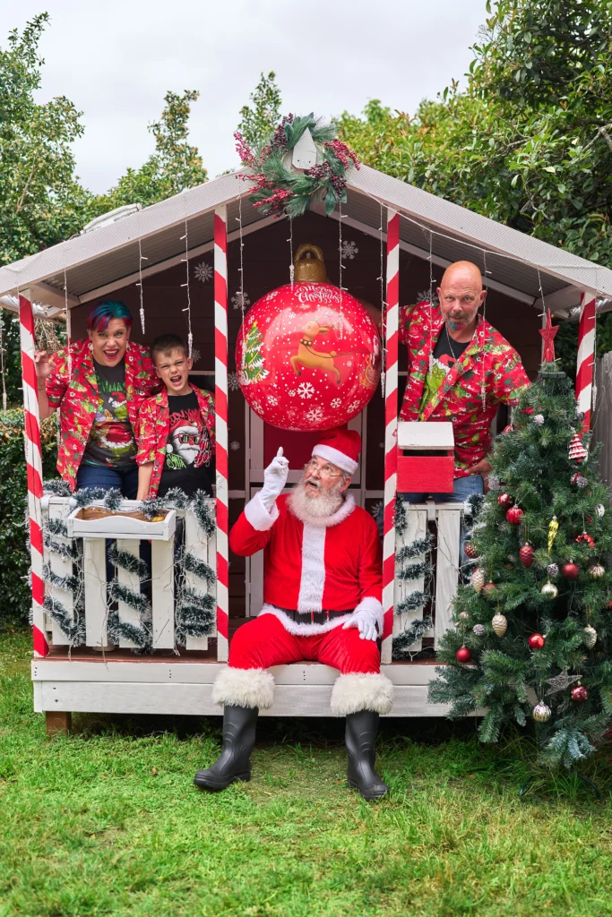 Family sits with reaSanta on porch