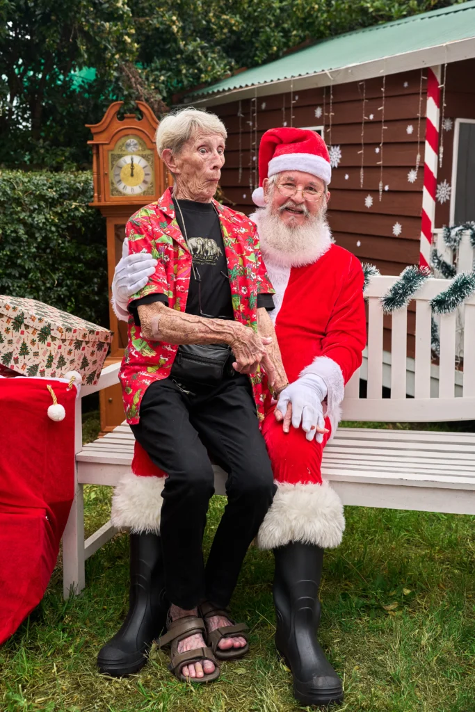 Man sits beside Santa outdoors